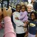 Langston Josey, 11, holds his two-year-old sister Sasha, as they along with their sister Martha, 8, pose for a photograph with Michigan women's basketball player Jenny Ryan during an open house at Crisler Arena on Friday evening. Melanie Maxwell I AnnArbor.com